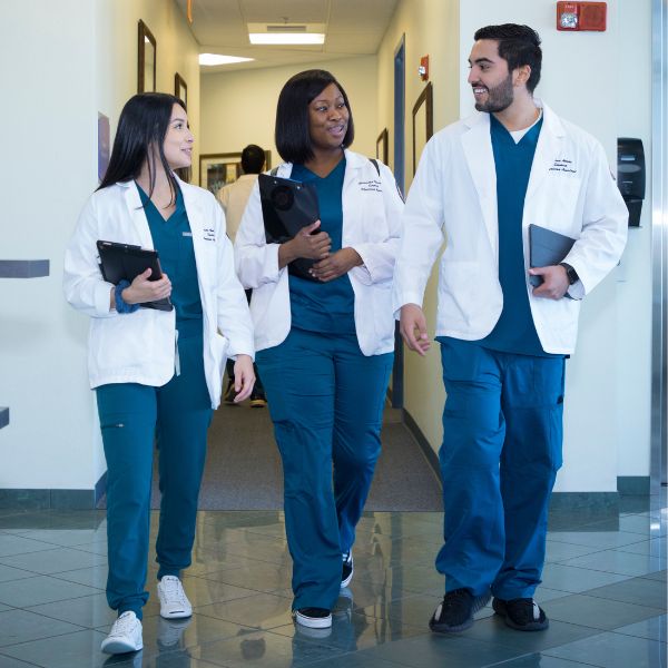 3 medical students walking through a hallway