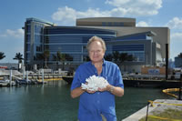NSU Oceanographic Center (OC) professor Richard Spieler, Ph.D., holds a piece of coral in front of NSU’s Center for Excellence for Coral Reef Ecosystems Science Research Facility.