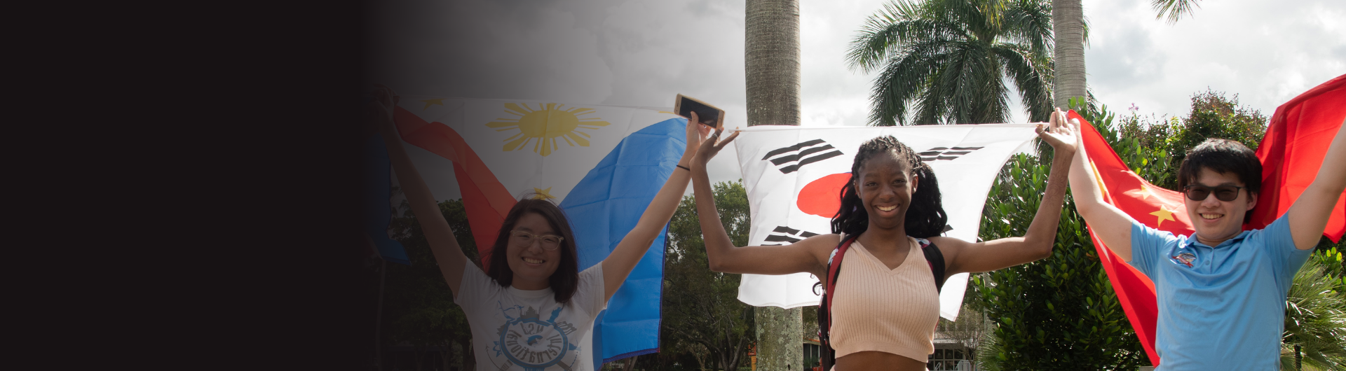 four international students hold the flags of their country