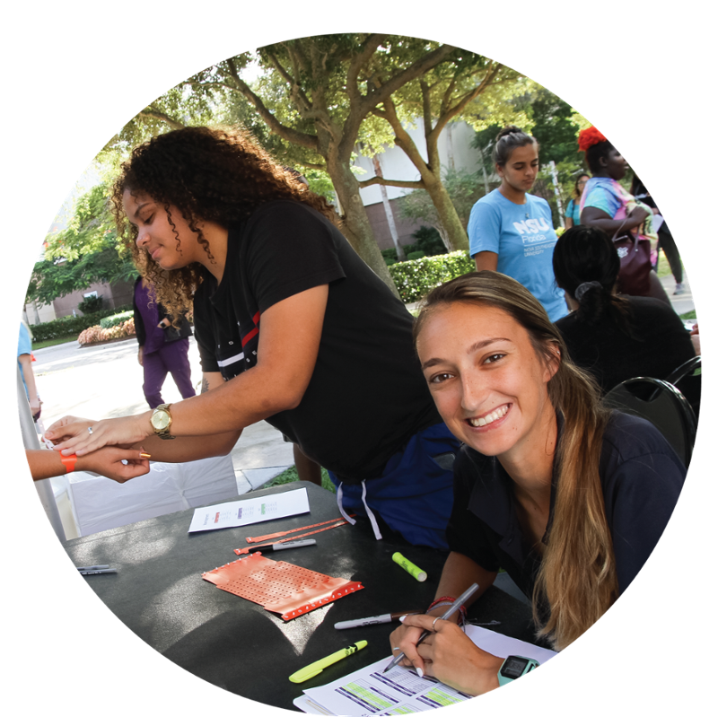 Diverse images of NSU students sitting at a booth at community fest