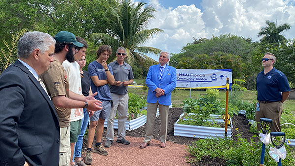 president hanbury with attendees of community garden opening