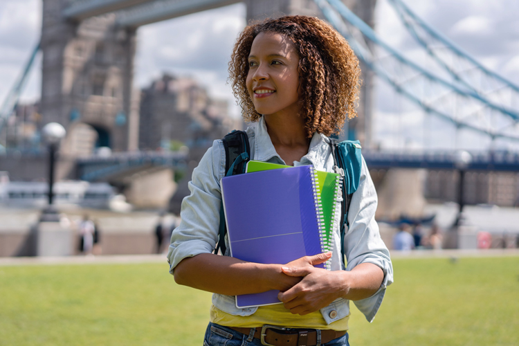 Student at abroad studies holding book