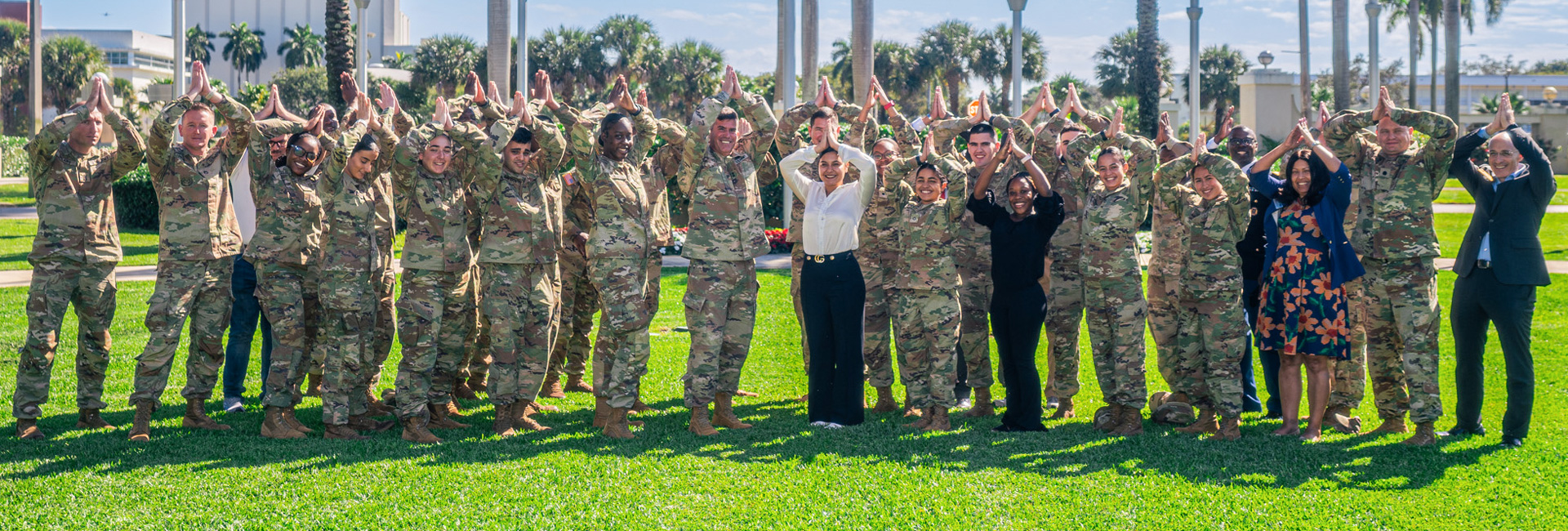 rotc nsu army class on outdoors group photo doing fins up