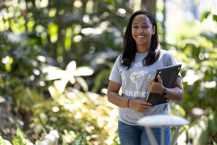 Portrait of a student smiling and holding a tablet