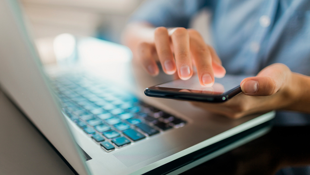 Person using laptop and cellphone