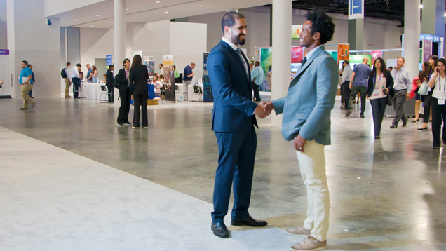 Graduate students technology students at event doing handshake