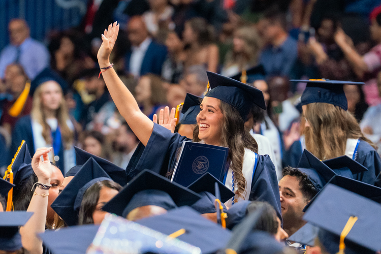 Commencement students waving on crowd