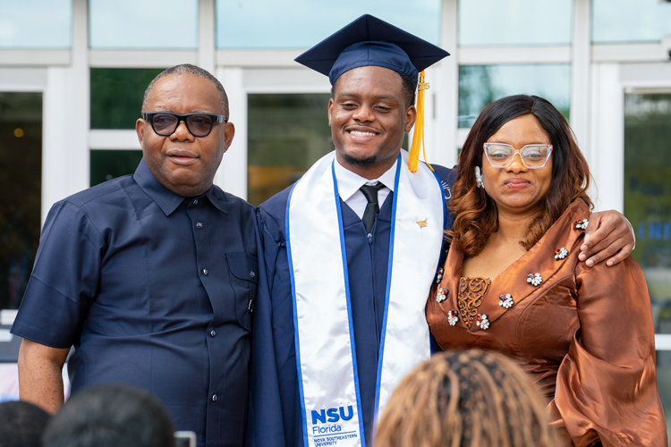 Graduate student with parents at commencent