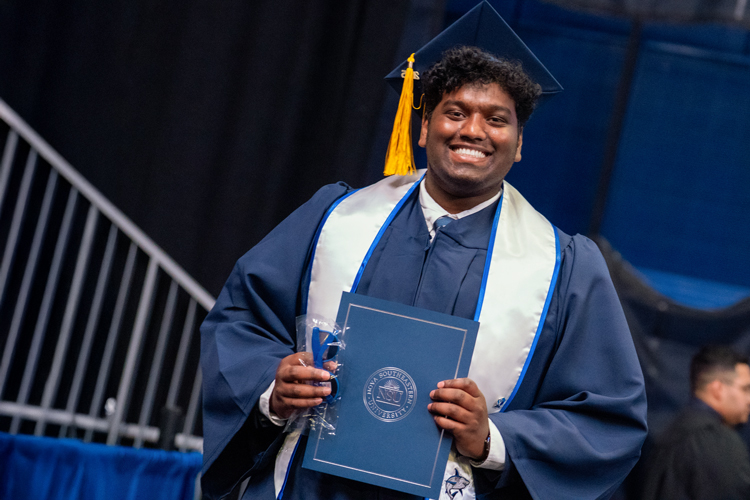 Student with cap and gown holding diploma