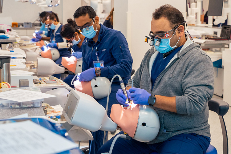 Dental students practicing on a manikin