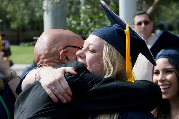 NSU graduate hugs and career graduation day with cap and gown