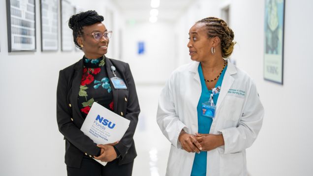 Two professionals walking and talking in hallway