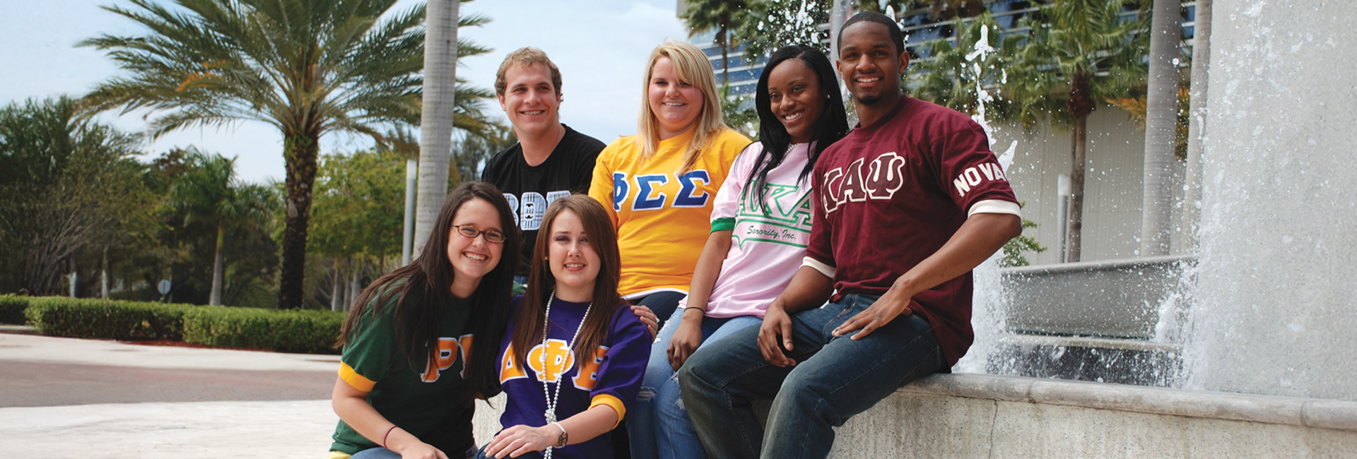 Fraternity and sorority members posing for a picture outdoors