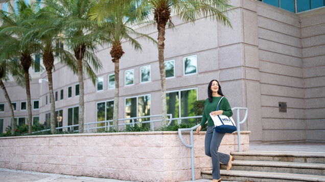 Graduate student walking on campus to get resources