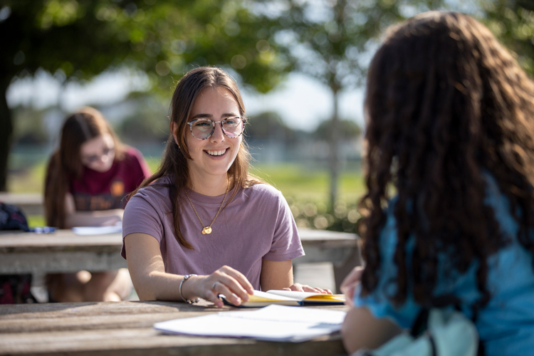 Female students speaking and studying on outdoors 