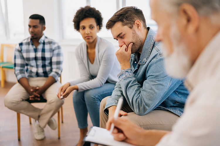 Group of people sitting in chairs during a therapy session