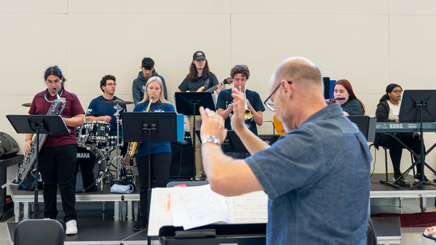 Diverse Mako band students with faculty