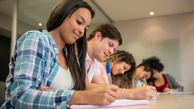 Group of students writing in their notebooks