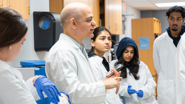 NSU professor and students in lab white coats