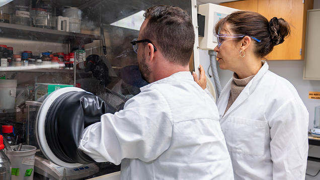 Two researchers using lab equipment