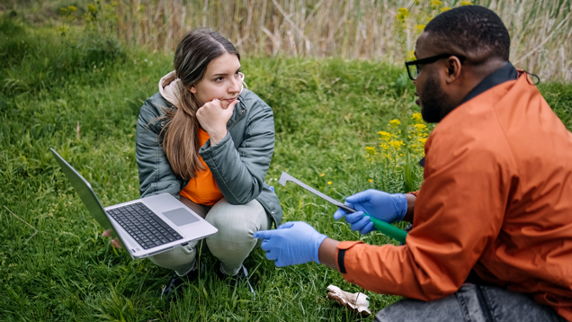 Two scientists doing research outdoors