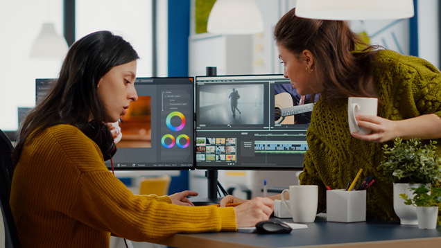 Two women working together while using a computer