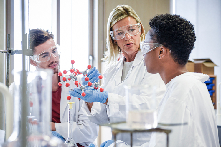 Chemistry teacher talking with her students in a lab