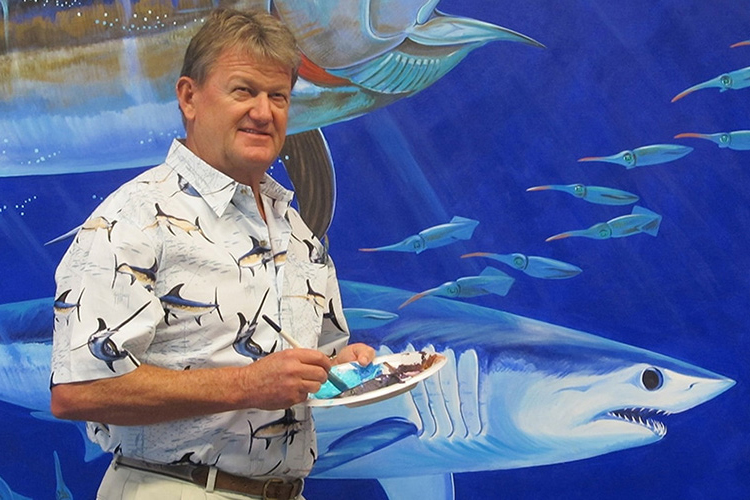NSU Halmos Guy Harvey standing next to wall art