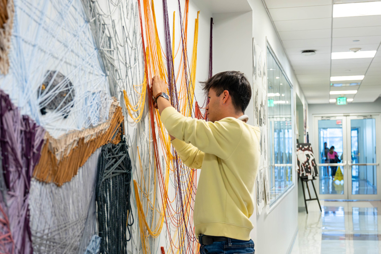 Student working on mix media wall art