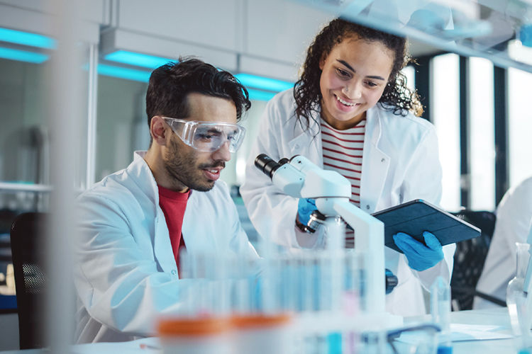 Two scientists using a microscope in a lab