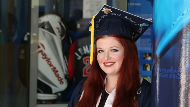 Smilling student wearing cap and gown