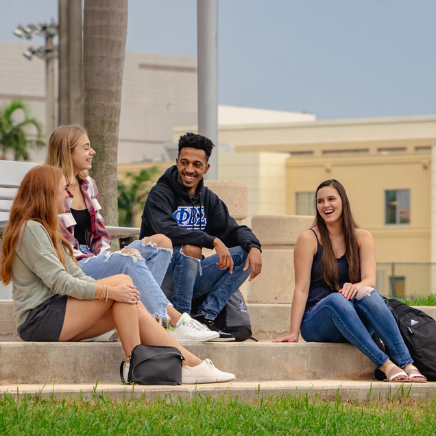 Group of students sitting on steps outside of building