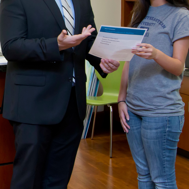 A student reviewing paper with a mentor