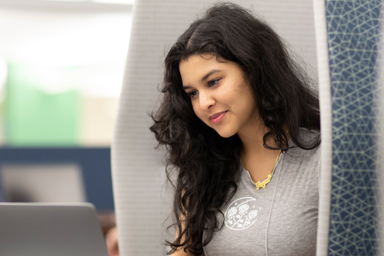 Student in chair looking down at laptop