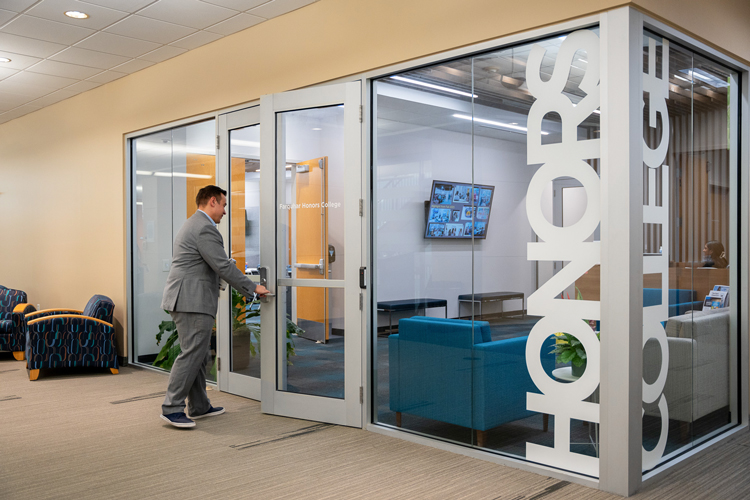 Student opening door of Honors suite