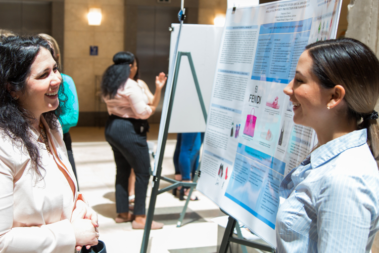 Students at the Student Symposium in front of poster presentation