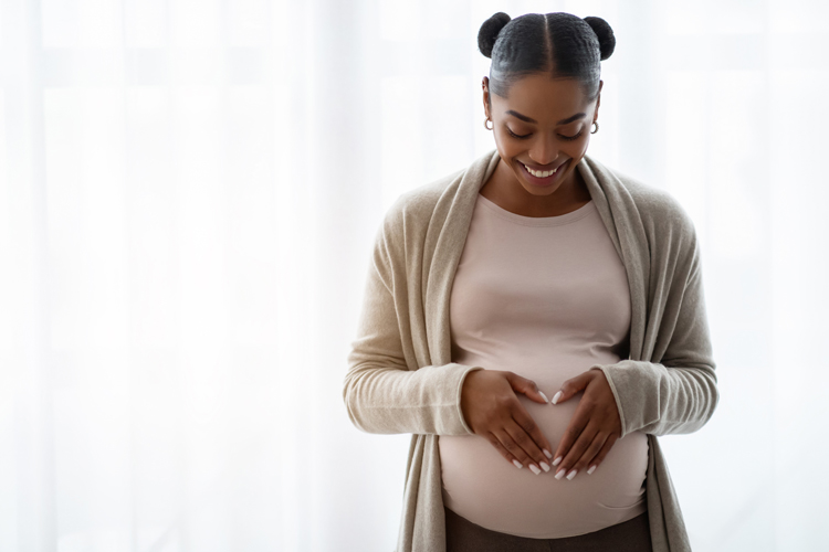 Pregnant women making heart on belly