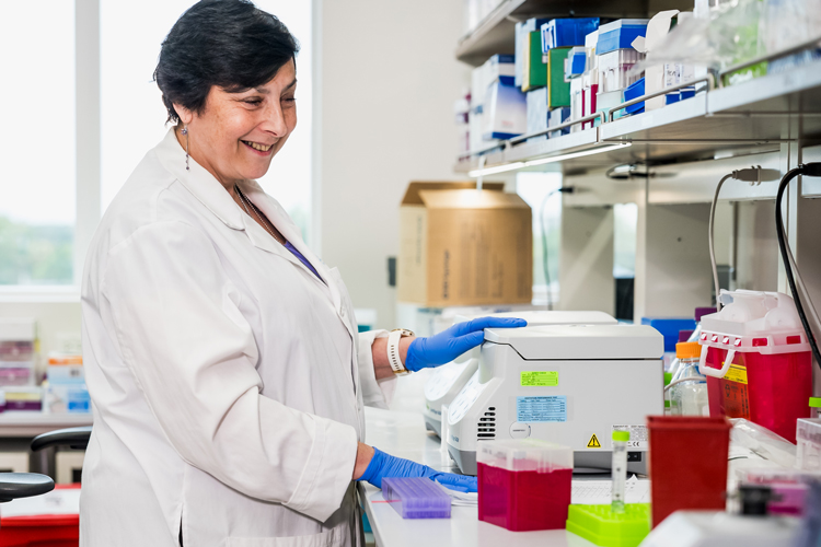 NSU research member Dr. Luvov working at the lab with white coat smiling