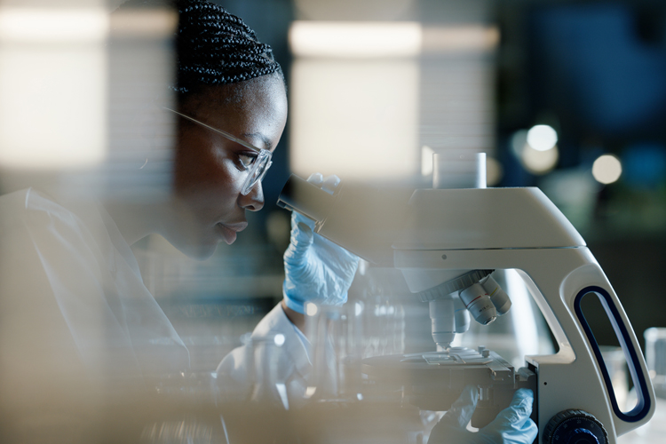 Scientist microscope analyzing in lab for healthcare innovation