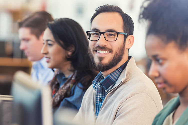 Group of people using computers in class