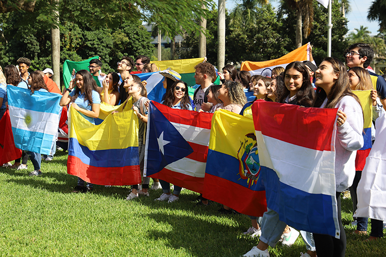 Group of students holding international flags outdoors