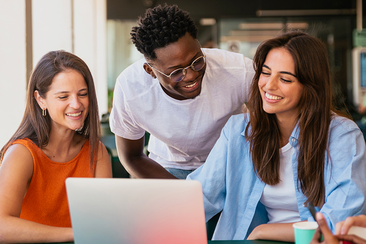 Group of students looking at a laptop