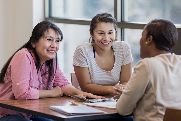 Mother and daughter talking to a woman about a student loan
