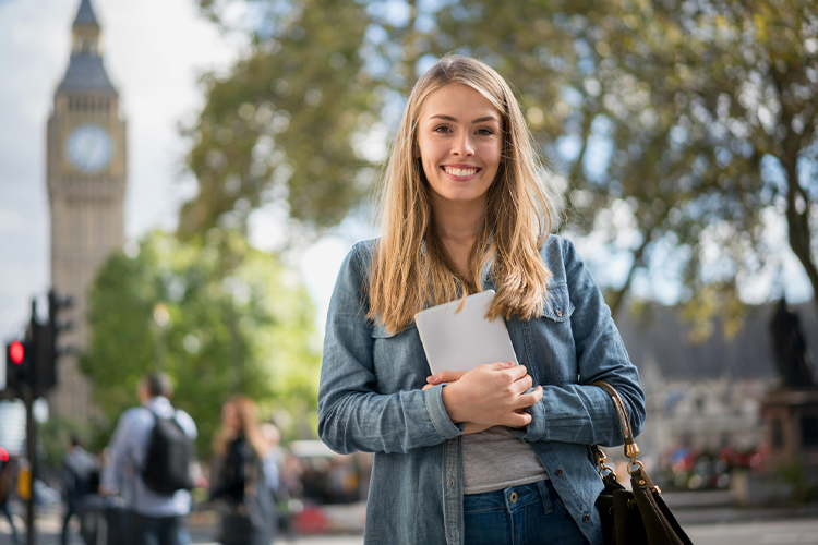 Student in London holding a digital tablet