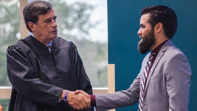 NSU faculty shaking hands with law student