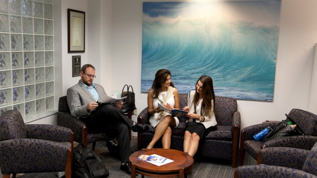 three NSU students reviewing materials in career services waiting room