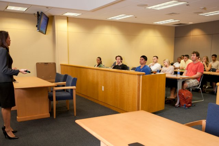 student attorney presenting to students in courtroom