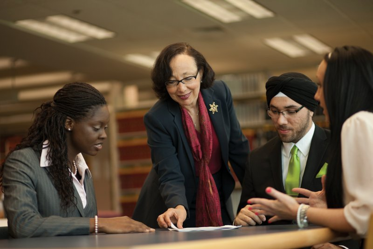 group of students meeting with a professor