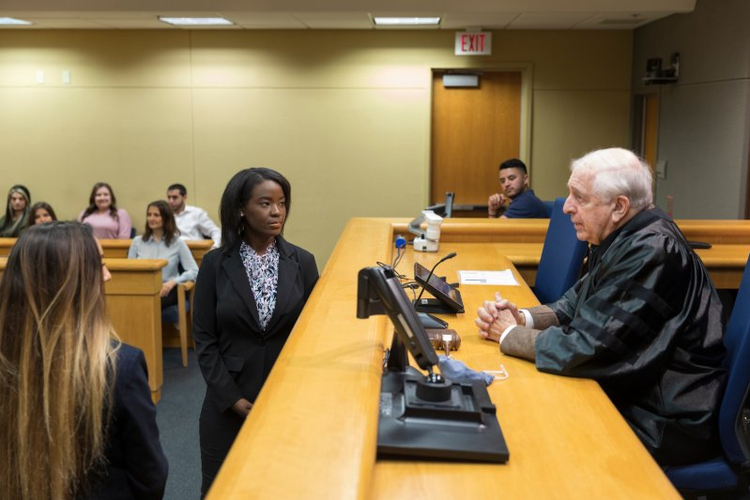 Student at podium facing judge