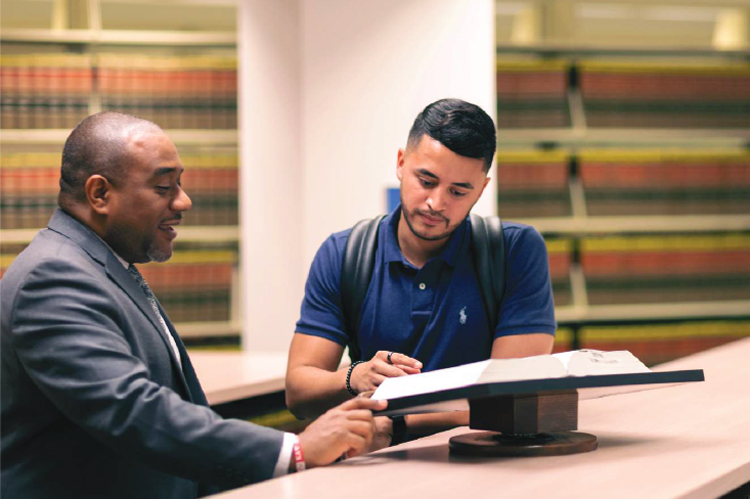 Nova Southeastern Law student going over book with law professor